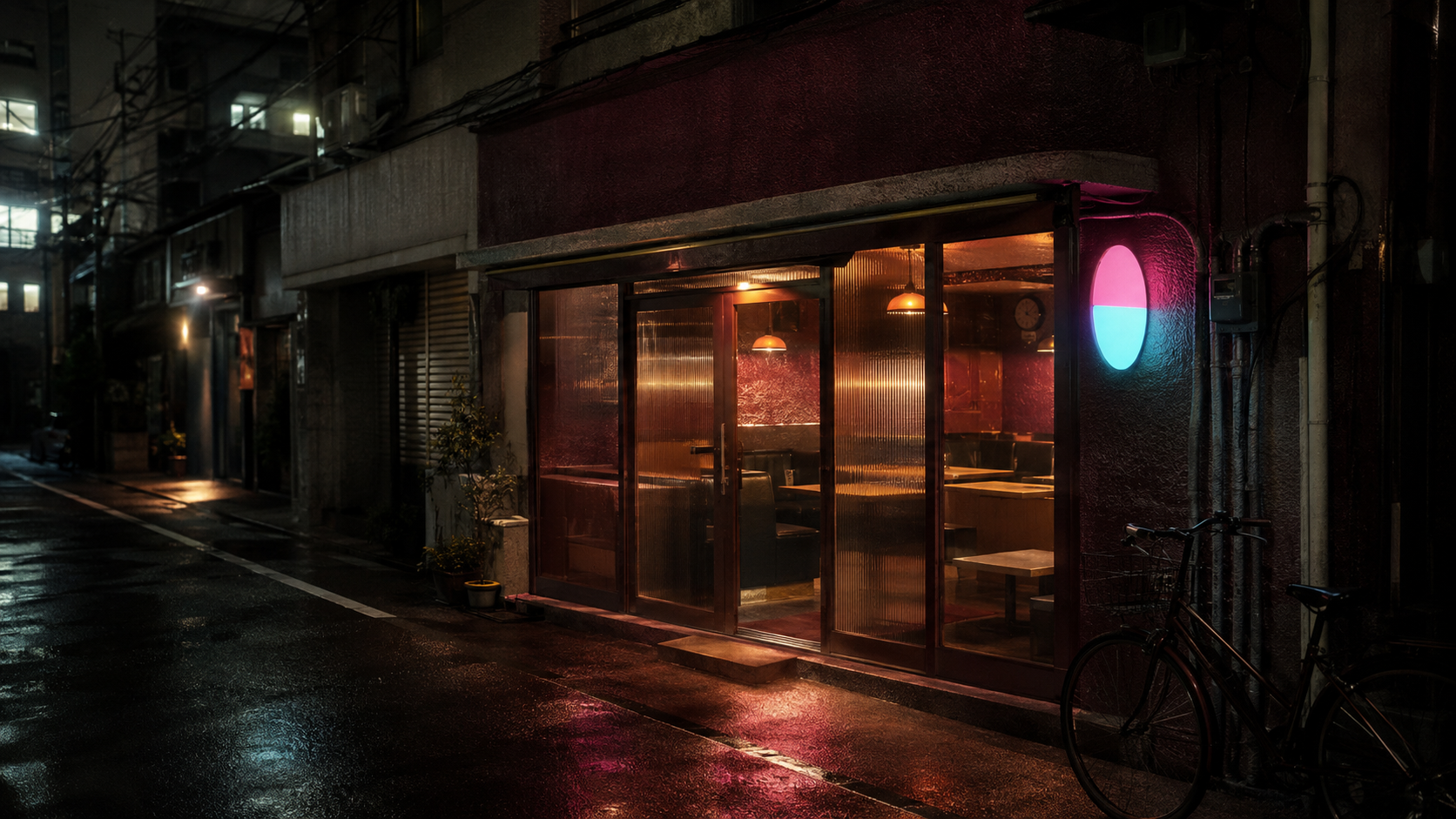 夜の路地に面した SAMPLE 喫茶 Neon の外観。ガラス越しに橙色の灯りがこぼれ、壁のピンクとシアンの丸看板が濡れた路面を照らしている。